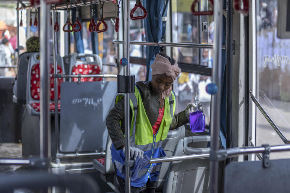 A volunteer disinfects a passenger bus as a precaution against the spread of the new coronavirus in the capital Addis Ababa, Ethiopia Wednesday, March 18, 2020. For most people, the new coronavirus causes only mild or moderate symptoms such as fever and cough and the vast majority recover in 2-6 weeks but for some, especially older adults and people with existing health issues, the virus that causes COVID-19 can result in more severe illness, including pneumonia. (AP Photo/Mulugeta Ayene)