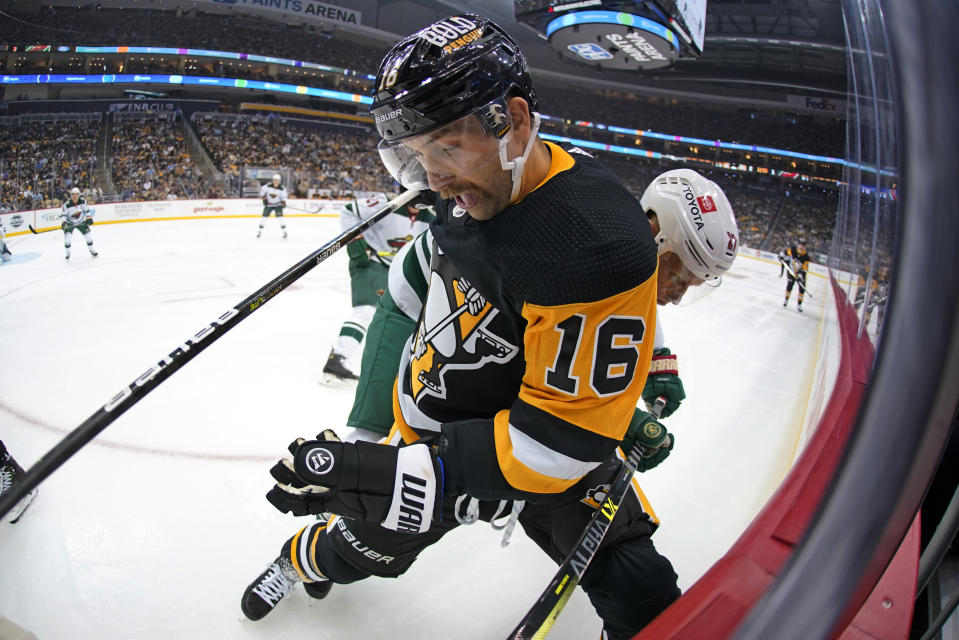 Pittsburgh Penguins' Jason Zucker (16) and Minnesota Wild's Nick Bjugstad (27) battle for puck possession during the second period of an NHL hockey game in Pittsburgh, Saturday, Nov. 6, 2021. (AP Photo/Gene J. Puskar)