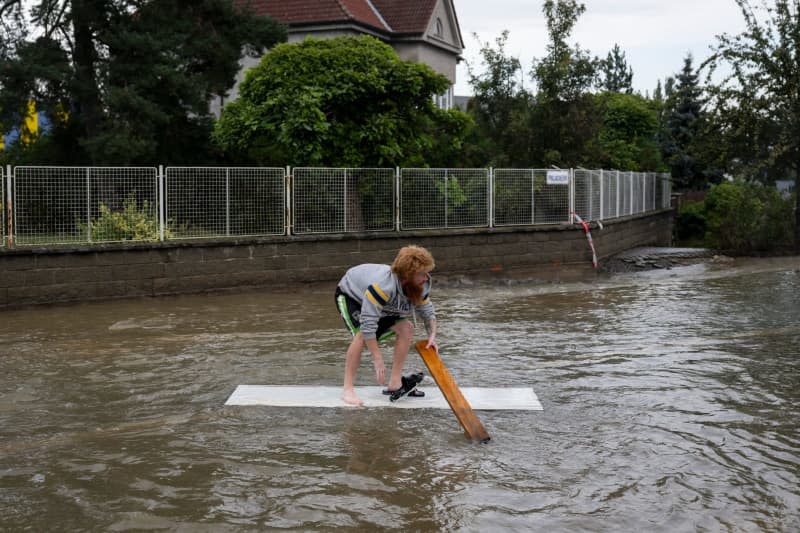 A man moves over a flooded street in Litovel in the east of the Czech Republic. Deml Ondøej/CTK/dpa