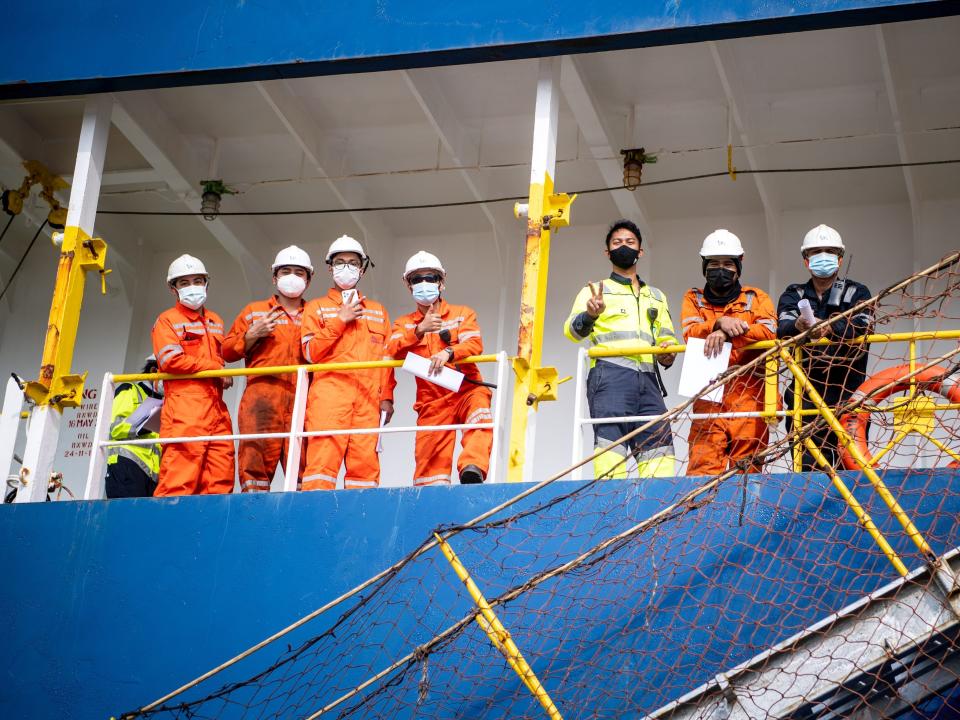 Seafarers with face masks on board a ship.