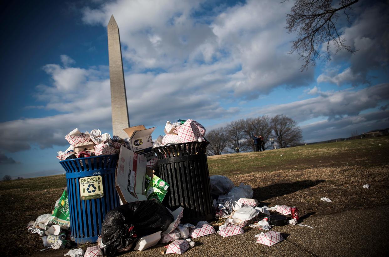 Litter spills out of a public dustbin next to the Washington Monument on the National Mall in Washington DC on December 24, 2018.  (Photo by Eric BARADAT/AFP/Getty Images)      