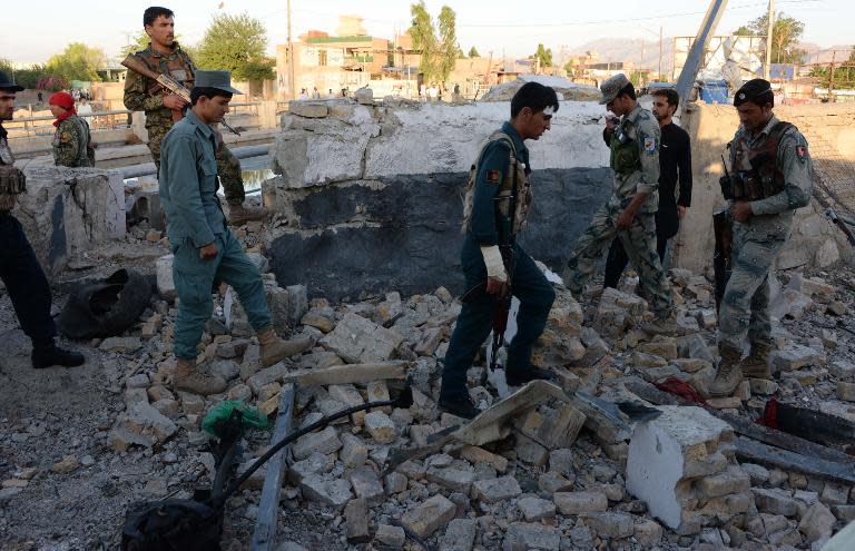 Afghan police and security inspect the site of a suicide attack targeting a police headquarters in Jalalabad, the capital of eastern Nangarhar province, on June 1, 2015