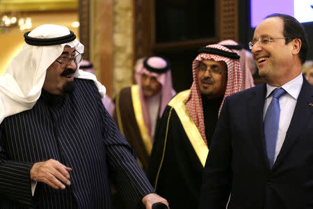 Saudi Arabia's King Abdullah bin Abdulaziz al-Saud speaks with French President Francois Hollande after their meeting at the Saudi Royal palace in Riyadh December 29, 2013. REUTERS/Kenzo Tribouillard/Pool