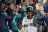 Seattle Mariners' Julio Rodriguez is congratulated in the dugout after hitting a two-run home run against the Oakland Athletics during the fifth inning of a baseball game Tuesday, May 24, 2022, in Seattle. (AP Photo/Ted S. Warren)