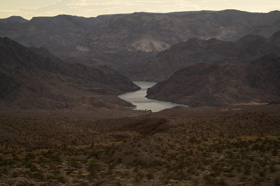 FILE - Water flows down the Colorado River downriver from Hoover Dam in northwest Arizona, on Aug. 14, 2022, near the Lake Mead National Recreation Area. In November 2022, some of the largest water agencies in the western United States agreed to a framework that would dramatically reduce the amount of decorative grass in cities such as Los Angeles, Las Vegas, Salt Lake City and Denver. The agreement comes as the seven states that rely on the overtapped Colorado River are facing a dire future with less water to go around. (AP Photo/John Locher, File)