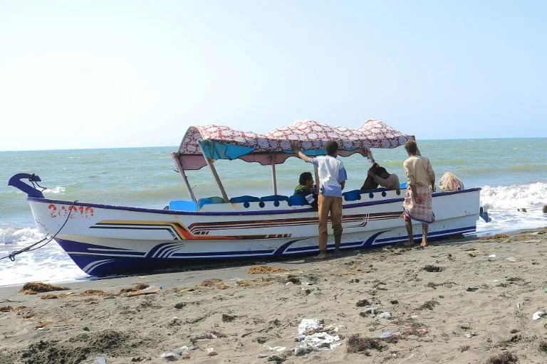 Yemenis ride a fishing boat on the coast of the Red Sea port of Hodeida (-)