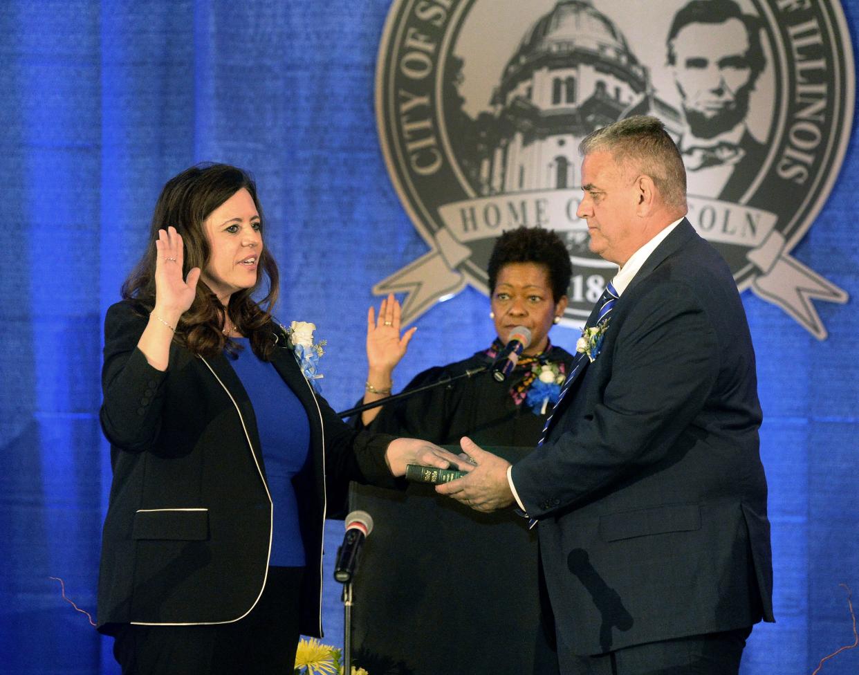 Mayor Misty Buscher, left, is sworn in by Illinois Supreme Court Justice Lisa Holder White, center, while Buscher's husband, Mike, holds the bible for her during the City of Springfield Inauguration Ceremony at the Bank of Springfield Center on Friday, May 5, 2023.