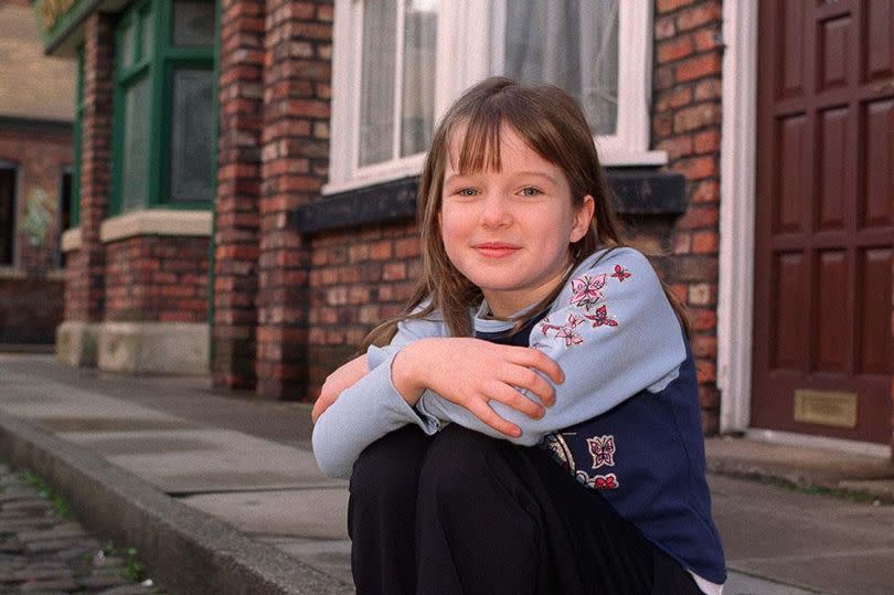 Helen Flanagan as a child, sitting on the curb