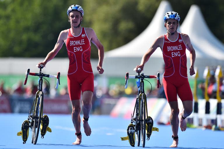 England's Alistair (L) and Jonathan Brownlee enter the transition zone during the men's Triathlon Final at Strathclyde Country Park near Glasgow during the 2014 Commonwealth Games in Glasgow, on July 24, 2014