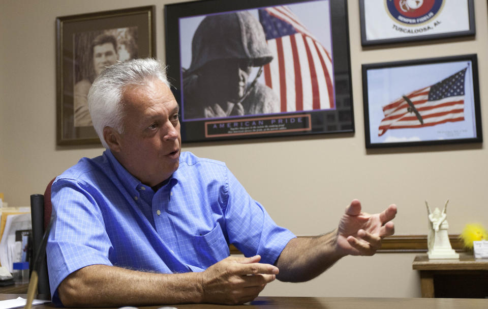 FILE - In this Aug. 9, 2011, file photo, Johnny Spann talks with reporters in his Winfield, Ala., real estate office. His son Mike Spann, a Marine turned CIA officer, felt a duty to go to Afghanistan in the wake of the Sept. 11, 2001, attacks, and in Nov. 2001, he was the first casualty of American service members to be killed in Afghanistan. (AP Photo/Dave Martin, File)