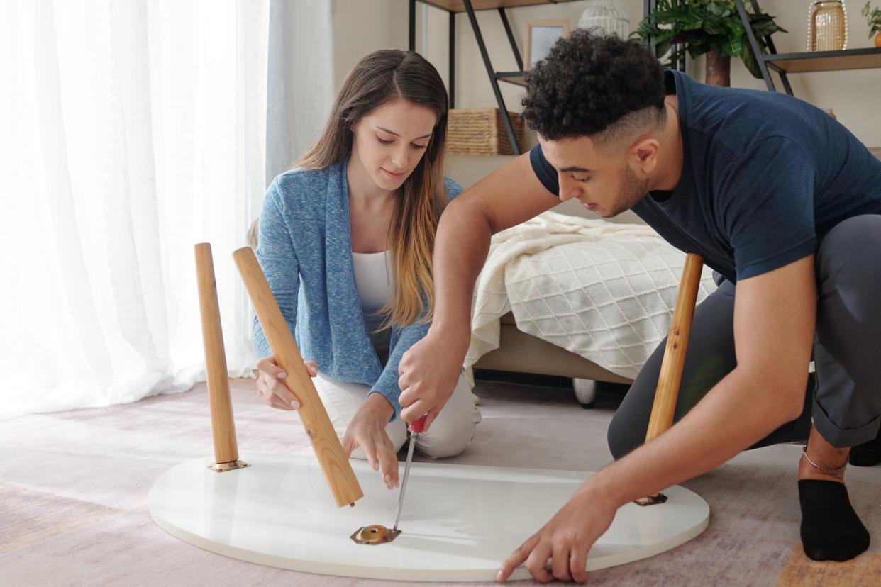 Young couple with screwdriver assembling coffee table they ordered online