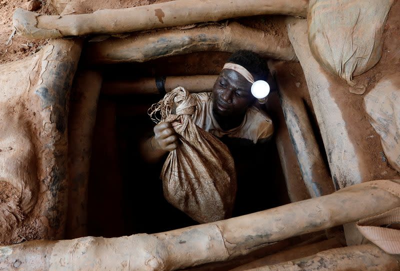 FOTO DE ARCHIVO: Un minero artesanal sale de una mina de oro con una bolsa de rocas rotas del interior del pozo de la mina en el sitio minero sin licencia de Nsuaem Top en Ghana, el 24 de noviembre de 2018