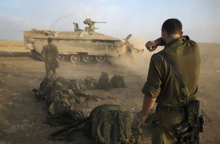 An Israeli soldier stands at a staging area after crossing back into Israel from Gaza July 28, 2014. Israel eased its assaults in the Gaza Strip and Palestinian rocket fire from the enclave declined sharply on Monday, the military said, with both the United States and United Nations calling for a durable ceasefire. REUTERS/Baz Ratner (ISRAEL - Tags: CIVIL UNREST CONFLICT MILITARY POLITICS)