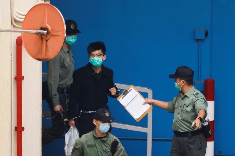 Pro-democracy activist Joshua Wong walks to a prison van to head to court with other activists, over a national security law charge, in Hong Kong