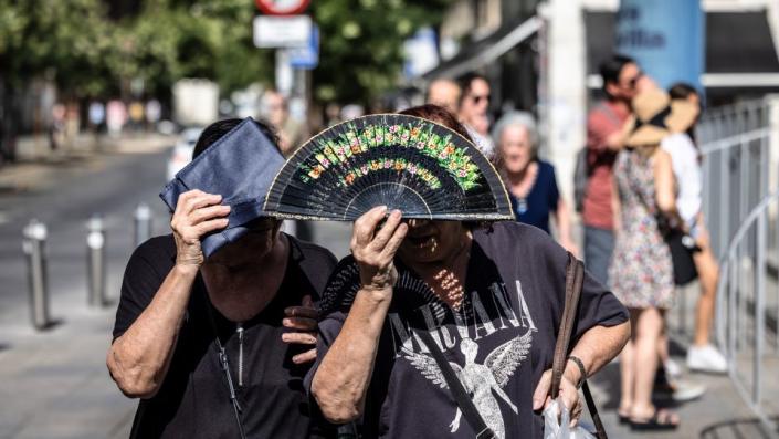 La gente se protege del sol durante las altas temperaturas en Sevilla, España, el jueves.  - Ángel García/Bloomberg/Getty Images