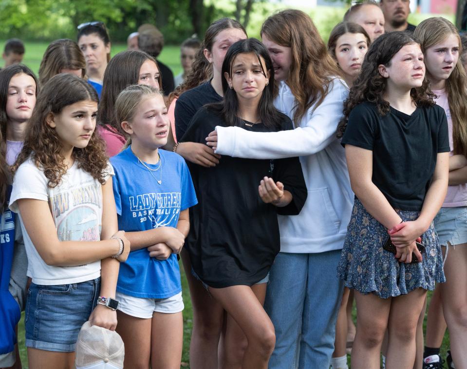 Friends of the Dunham children comfort each other during a vigil Saturday for the Dunham family at Hartville Memorial Park. The family died earlier this week in what police described as a homicide-suicide.