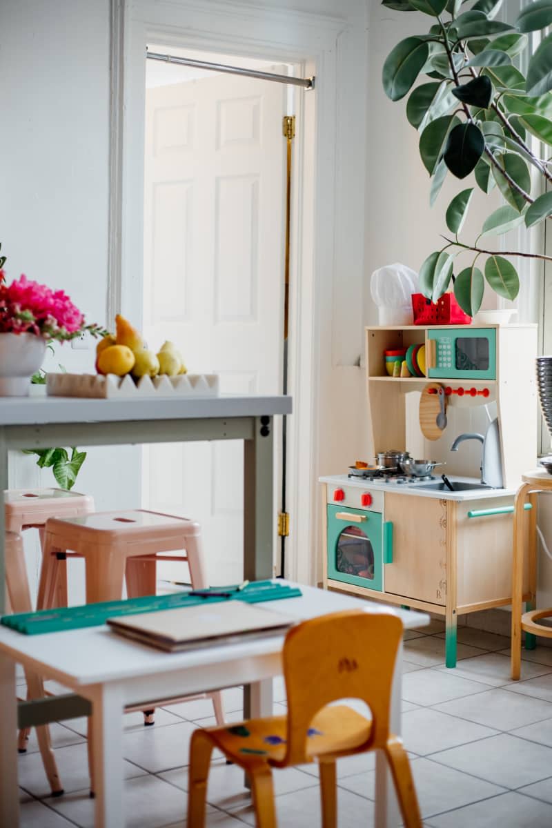 Child's wooden play kitchen in corner of home kitchen.