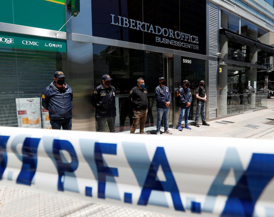 <p>Police stand guard outside the Buenos Aires office of Dr Leopoldo Luque</p> (Reuters)