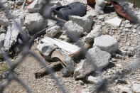 FILE - A shoe is seen amid debris at the edge of what remains of the Champlain Towers South condominium building Thursday, May 12, 2022, in Surfside, Fla. Attorneys for the families who lost relatives or homes in last year’s collapse of a Florida condominium tower that killed 98 people finalized a $1 billion settlement on Friday, May 27, 2022. (AP Photo/Marta Lavandier, File)