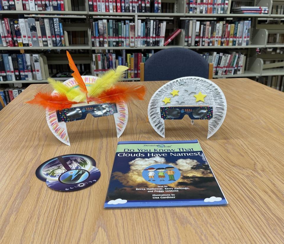 This photo, taken at the Somerset County Library, includes two pairs of stylish eclipse glasses made by young patrons, as well as a pinhole viewer (foreground, left) and a book for children that talks about the different types of clouds.