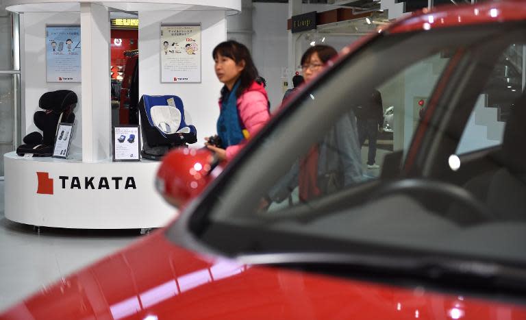 Visitors look at displays of Japanese auto parts maker Takata Corp at a car showroom in Tokyo on November 11, 2014