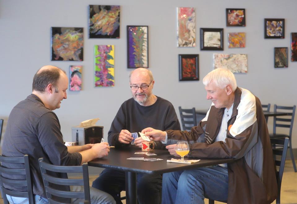 From left, Jeff Archinal, Glen Archinal, and Walt Grandal sip on their favorite beer while playing a friendly game of euchre at Brighten Brewing Company on March 8.