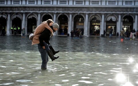 Tourists were out on St Mark's Square on Thursday despite the conditions - Credit: Reuters