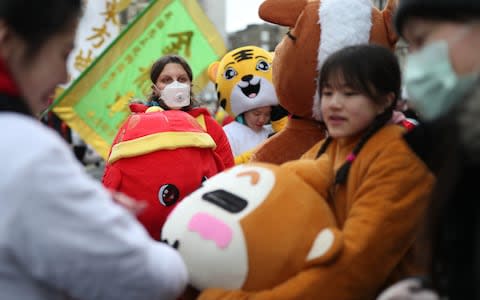 A performer wears a face mask during Chinese New Year celebrations in central London, which mark the start of the Year of the Rat - Credit: PA