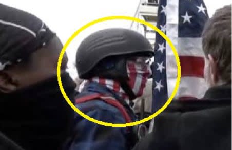 Public source video shows Homol with a red, white, and blue scarf covering his face.