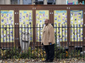 Tommie Bosley stands for a portrait in front of a display of gun violence victims on the lawn of St. Sabina Church in Chicago, Friday, Nov. 9, 2018. Bosley heads Strong Futures, a jobs-mentoring program at the church for young adults, many with criminal pasts, who are looking to get a new start on life. Among the photos in the glass-enclosed case is one of Bosley's 18-year-old son, Terrell, who was killed in 2006 while unloading musical instruments in a church parking lot. (AP Photo/Nam Y. Huh)