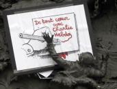 A placard with a press cartoon by cartoonist Plantu is placed amongst a frieze on the Republic statue at the Place de la Republique in Paris January 8, 2015. REUTERS/Gonzalo Fuentes