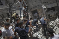 Palestinians search for bodies and survivors in the rubble of a residential building destroyed in an Israeli airstrike in Khan Younis, southern Gaza Strip, Tuesday, June 25, 2024. (AP Photo /Jehad Alshrafi)