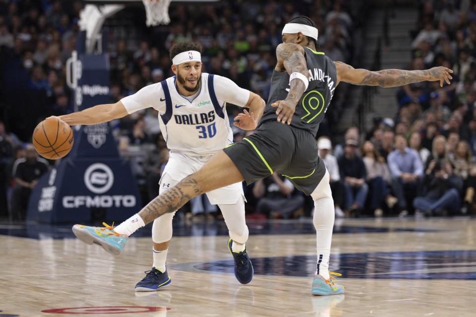 Minnesota Timberwolves guard Nickeil Alexander-Walker (9) reaches his leg out to block a pass from Dallas Mavericks guard Seth Curry (30) during the second half of an NBA basketball game, Wednesday, Jan. 31, 2024, in Minneapolis. (AP Photo/Bailey Hillesheim)