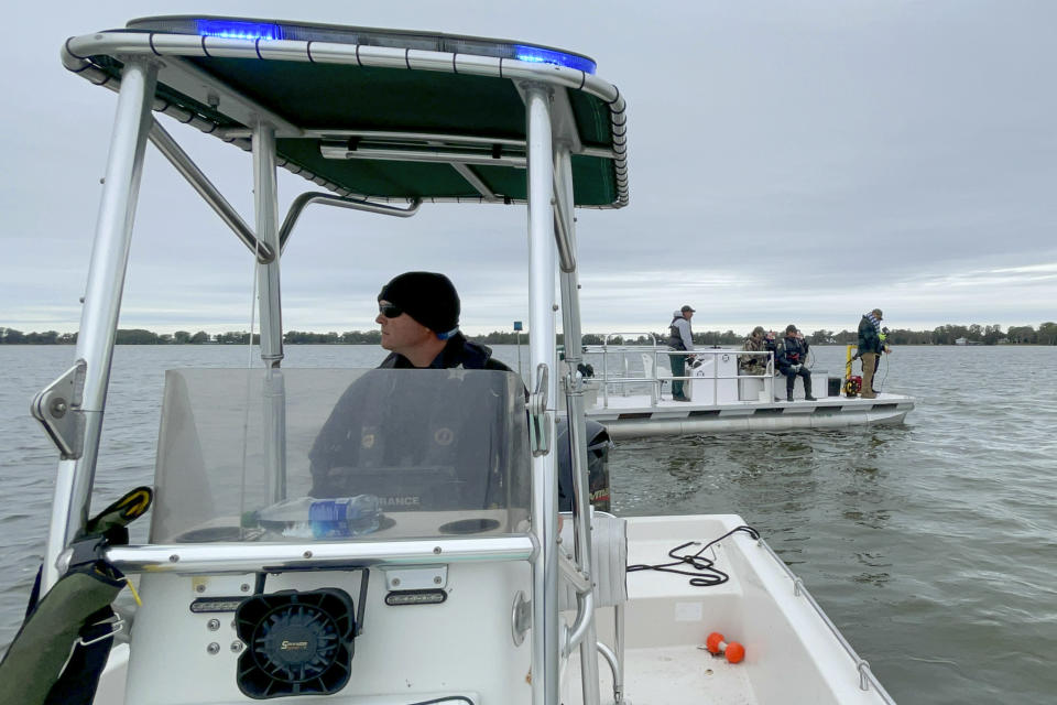 This photo released by the Polk County Sheriff's Office shows authorities searching for two missing boaters in Lake Eloise, on Sunday, March 19, 2023, in Winter Haven, Fla. (Polk County Sheriff's Office via AP)