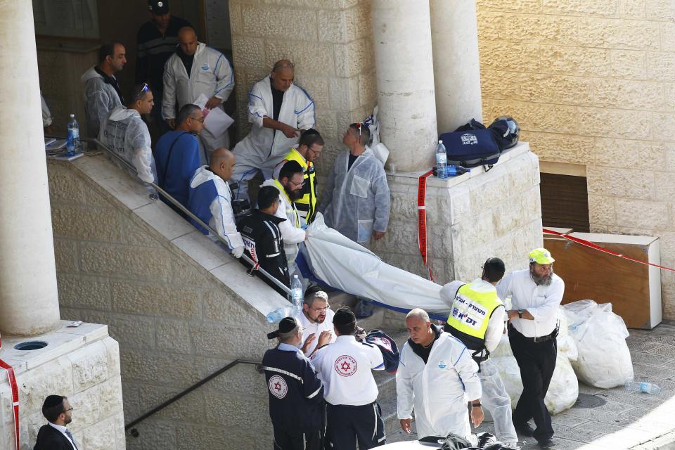 Israeli emergency personnel carry the body of a victim from the scene of an attack at a Jerusalem synagogue