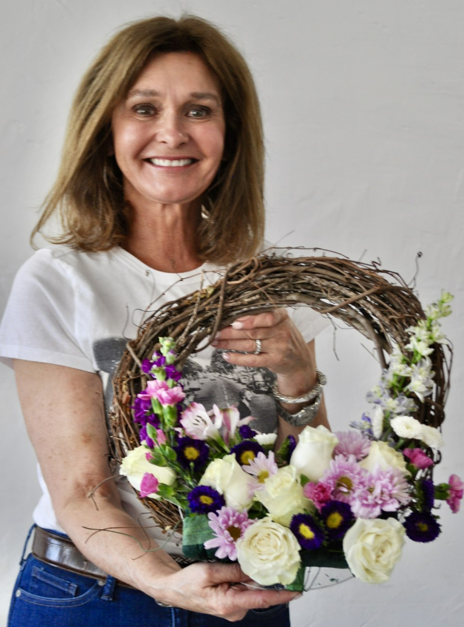 El Dedon Verde Garden Club member Leslie Beckoff shows off a sample wreath of flowers made for the Designer's Choice category, "I heard it through the grapevine." The annual flower show will be April 25 at the El Paso Country Club.