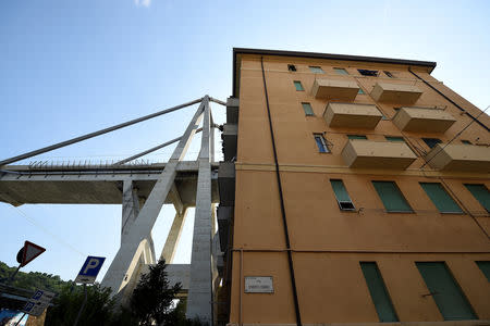A view of the collapsed Morandi Bridge and residential buildings, seen from the "red zone" restricted area in Genoa, Italy August 17, 2018. REUTERS/Massimo Pinca