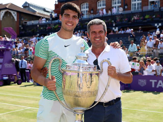 <p>Luke Walker/Getty</p> Carlos Alcaraz of Spain poses with the winner's trophy alongside father, Carlos Snr. after victory durring the Men's Singles Final match on Day Seven of the cinch Championships in 2023