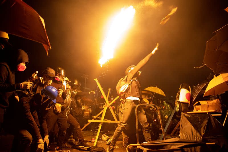 FILE PHOTO: Anti-government protesters throw molotov cocktails during clashes with police, outside Hong Kong Polytechnic University (PolyU) in Hong Kong