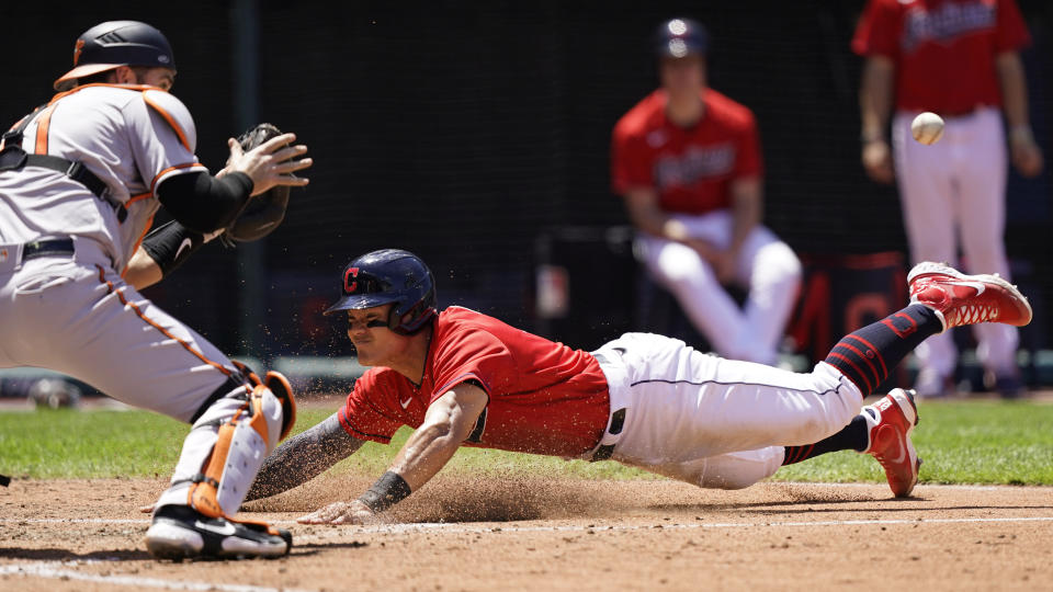 Cleveland Indians' Yu Chang, right, slides safely into home plate as Baltimore Orioles' Austin Wynns waits of the ball in the fourth inning of a baseball game, Thursday, June 17, 2021, in Cleveland. (AP Photo/Tony Dejak)