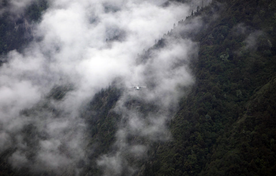 In this Tuesday, May 28, 2013 photo, a flight approaches Lukla airport, Nepal. Carved out of the side of a mountain, the airport was built by Sir Edmund Hillary in 1965, and at an altitude of 2,843 meters (9,325 feet) it has earned the reputation of being one of the most extreme and dangerous airports in the world. (AP Photo/Niranjan Shrestha)