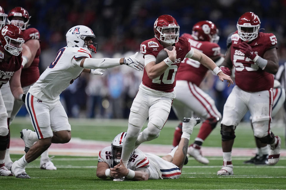 Arizona defensive lineman Tyler Manoa (92) grabs the foot of Oklahoma quarterback Jackson Arnold (10) during the first half of the Alamo Bowl NCAA college football game in San Antonio, Thursday, Dec. 28, 2023. (AP Photo/Eric Gay)