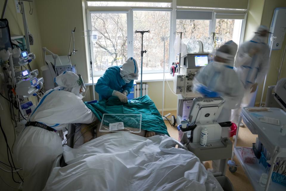 Medics wearing a special suit to protect against coronavirus treat a patient with coronavirus at an ICU at the Moscow City Clinical Hospital 52, in Moscow, Russia, Tuesday, Oct. 19, 2021. Russia hit another daily record of coronavirus deaths Tuesday as rapidly surging infection rates raised pressure on the country's health care system and prompted the government to suggest declaring a nonworking week.(AP Photo/Alexander Zemlianichenko)