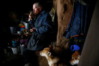 Yuri Baikov, 69, drinks coffee inside his hut situated in a forest near the village of Yukhovichi, Belarus, February 8, 2018. REUTERS/Vasily Fedosenko