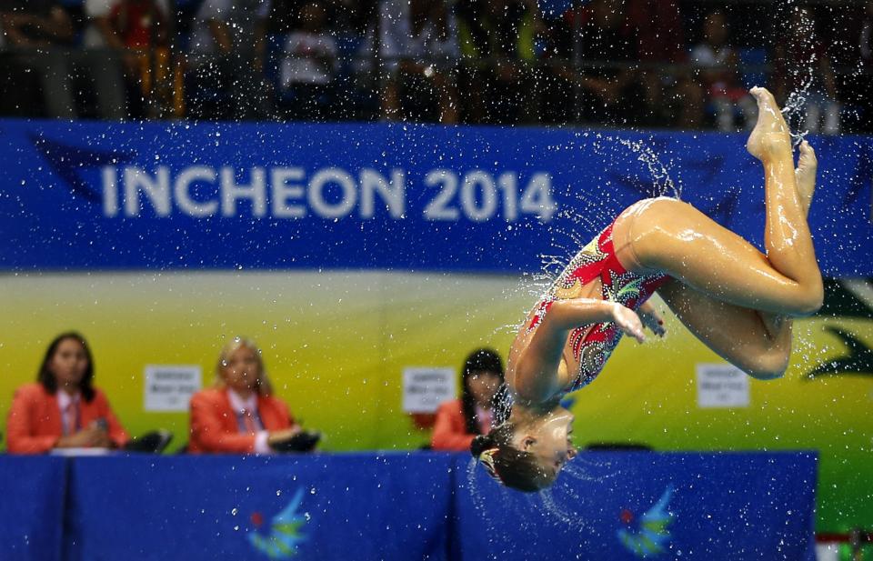 Judges watch a member of the bronze medal winning Kazakhstan team performing during their Synchronised Swimming Free Combination routine during the 17th Asian Games in Incheon