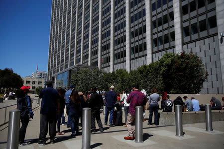 People wait outside the Phillip Burton Federal Building & United States Courthouse during a major power outage in San Francisco, California, U.S., April 21, 2017. REUTERS/Stephen Lam