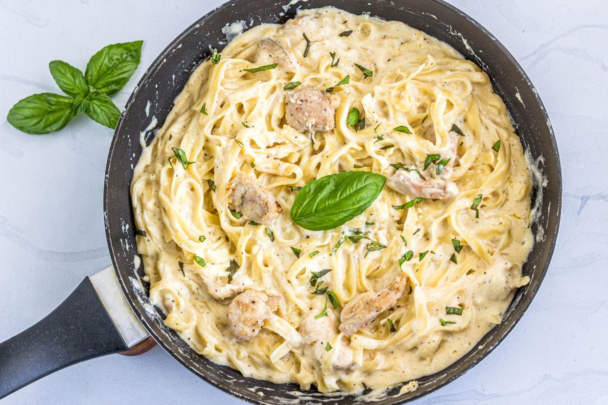 One Pot Chicken Alfredo Pasta in a Skillet Directly from Above Photo. Creamy Chicken Pasta with Basil Leaves, Italian Food Photography.