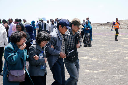 Members of a Chinese family mourn their son who died in the Ethiopian Airlines Flight ET 302 plane crash after a commemoration ceremony at the scene of the crash, near the town of Bishoftu, southeast of Addis Ababa, Ethiopia March 13, 2019. REUTERS/Baz Ratner