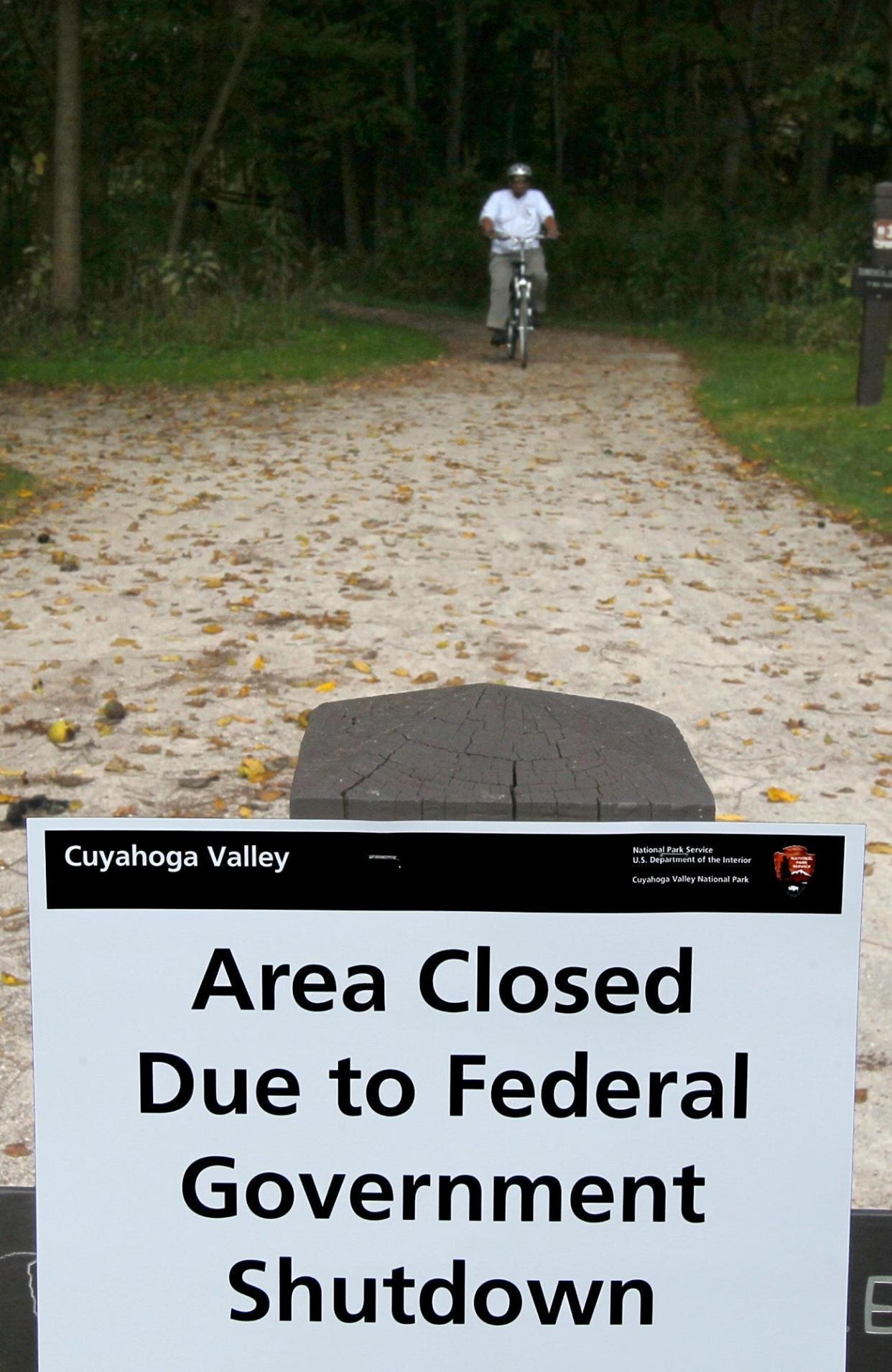 A sign posted in October 2013 at the Botzum Trailhead of the Cuyahoga Valley National Park alerts visitors to the area's closure due to a government shutdown. Ten years later, the threat of another shutdown looms this weekend.