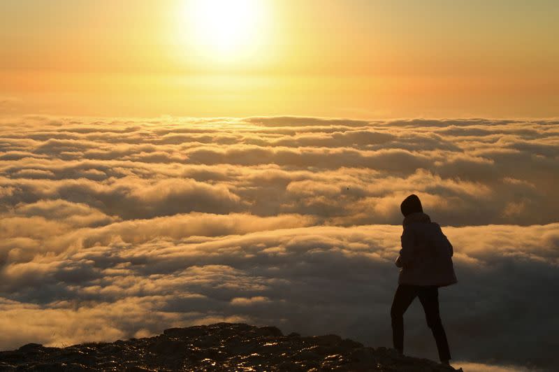 FILE PHOTO: A tourist admires the view while standing on the Ai-Petri peak near Yalta